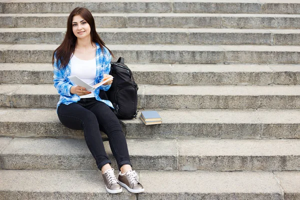 Młody student szczęśliwy kobieta z książek i siedzi na plecak — Zdjęcie stockowe