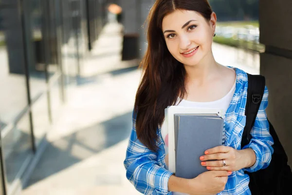 Öğrenci kız kitap ve modern cephe duran sırt çantası ile — Stok fotoğraf