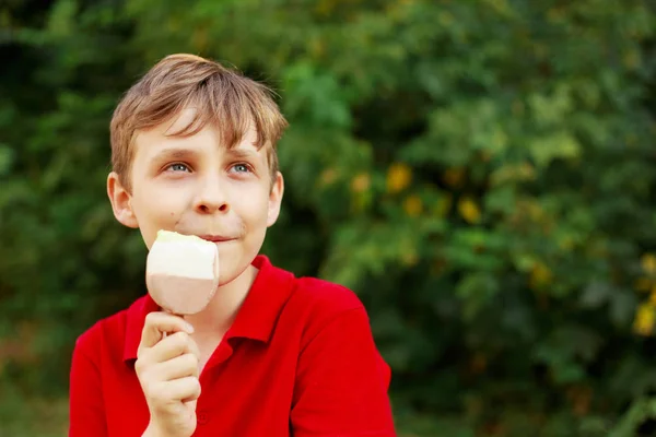Happy smiling boy eating ice-cream and dreaming. Childhood, fami