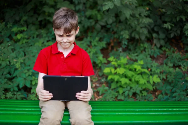 Vício em jogos eletrônicos. Enthralled menino brincando com tablet . — Fotografia de Stock