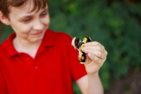 Lyckligt leende pojke leker med fidget spinner, närbild. Trendiga — Stockfoto