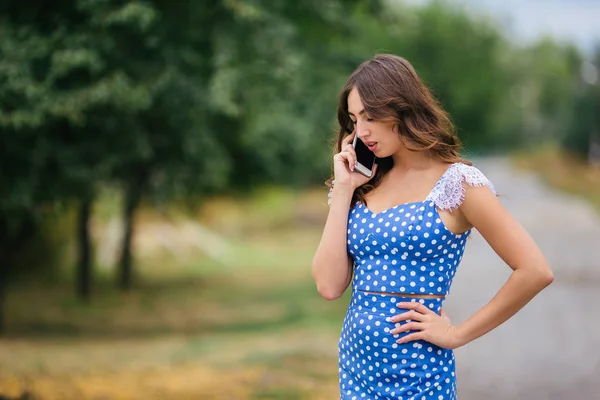 Kobieta rozmawia na inteligentnego telefonu na zewnątrz. — Zdjęcie stockowe