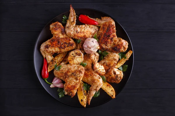 Limon ve sarımsak siyah plaka üzerinde ızgara tavuk kanatları. Cook