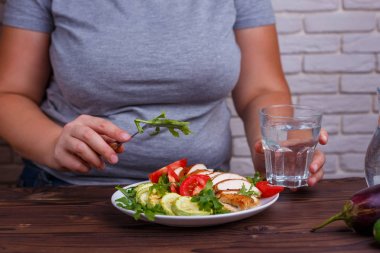 Diyet kavramı, sağlıklı yaşam, düşük kalorili gıda. Şişman kadın yemek