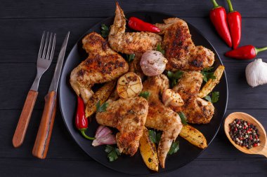 Sarımsak, Kenneth'in ile dekore edilmiş siyah plaka üzerinde ızgara tavuk kanatları