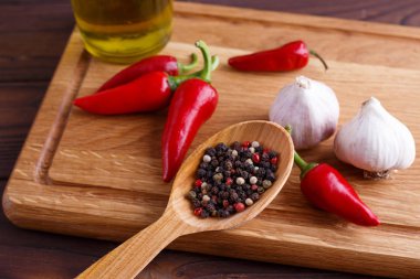 Bir tahta kaşık, biber, sarımsak, zeytin oi karışık biber