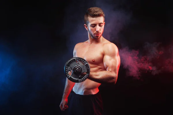 Muskulöser Bodybuilder, der Übungen mit Hantel über Blac macht — Stockfoto