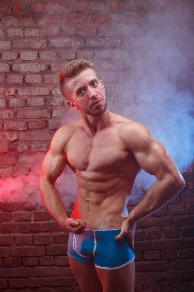 Jovem fit homem fisiculturista com perfeito grandes músculos surpreendido loo — Fotografia de Stock