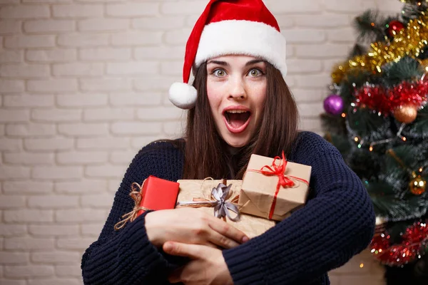 Young beautiful amazed happy woman in Santa cap with many gift b — Stock Photo, Image