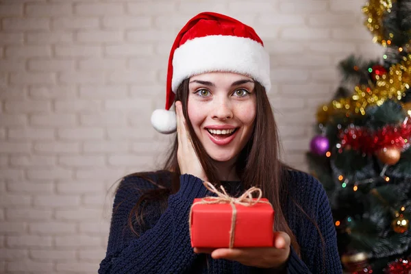 Young beautiful happy surprised woman in Santa cap with a gift b — Stock Photo, Image