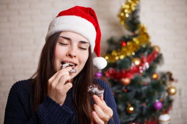 Genç güzel mutlu sürpriz kadın zencefil ısırma Santa şapkalı