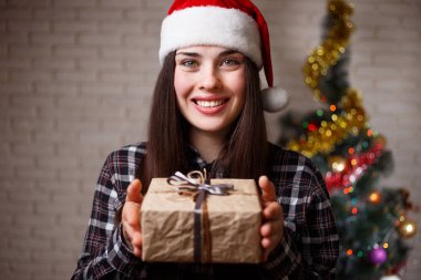 Noel Baba şapkalı genç sevimli kadın chris bir hediye almak mutludur