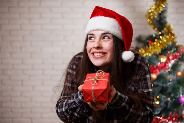 Young cute amused charming woman in Santa cap with funny face an — Stock Photo, Image