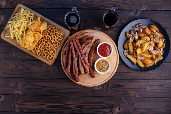 Oktoberfest food, pub concept. Two mugs of dark beer with great