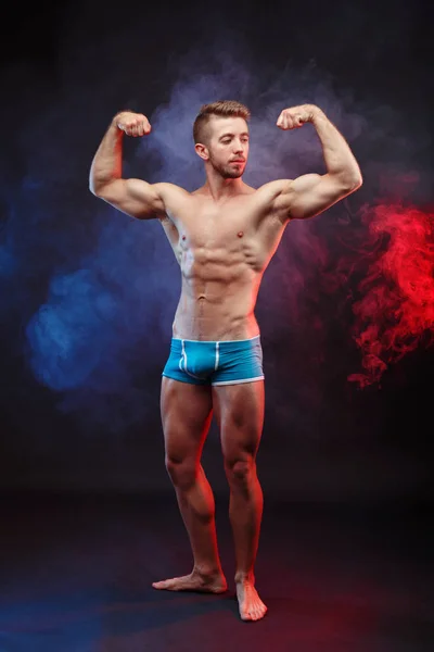 Young handsome muscular man demonstrating perfect body.Vertical — Stock Photo, Image