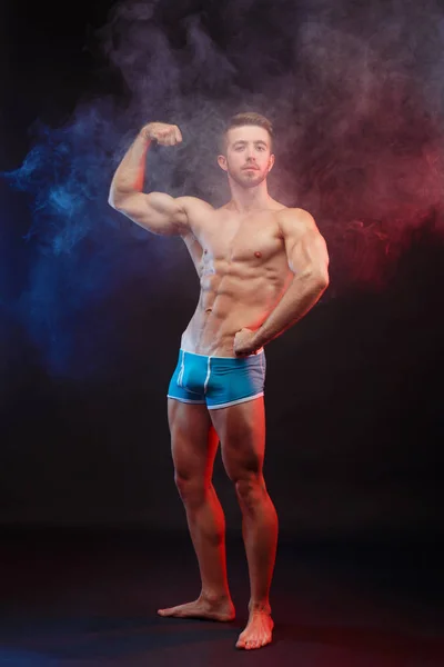 Genç adam vücut geliştirmeci bitti mükemmel büyük kasların esneme yerleştirmek — Stok fotoğraf