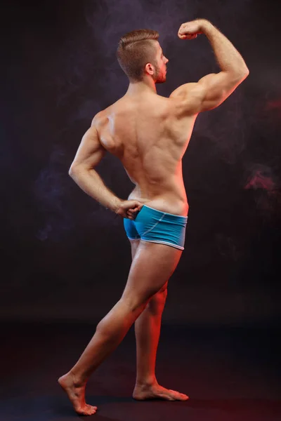 Visão traseira do fisiculturista homem musculoso rasgado com corpo perfeito p — Fotografia de Stock