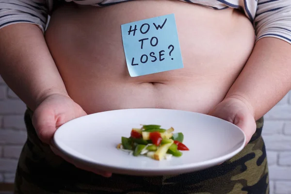 Mujer gorda con sobrepeso con una pequeña porción de comida preguntando cómo —  Fotos de Stock