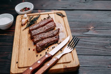 Ahşap kesme tahtası ile dilimlenmiş iyi pişmiş ızgara sığır eti biftek