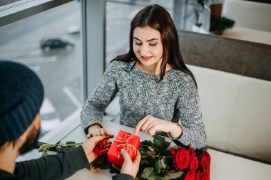 Sevgililer günü hediyesi. Adam bir hediye ve çiçek Merhaba sunulması