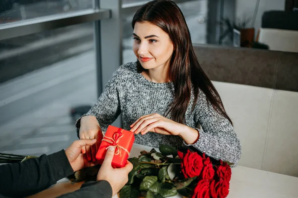 Pareja joven enamorada se hacen un regalo el uno al otro en San Valentín —  Fotos de Stock