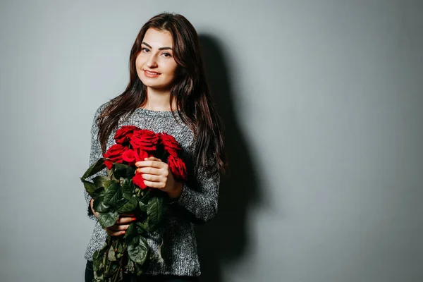 赤いバラの花束を持って若い美しい魅力的な女性。G — ストック写真