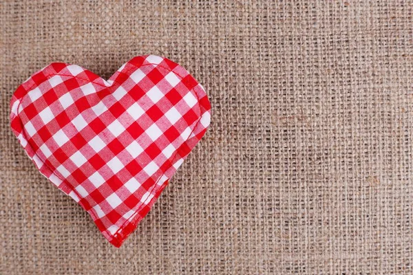 Valentijnsdag achtergrond. Handgemaakte geruite stof hart op sa — Stockfoto