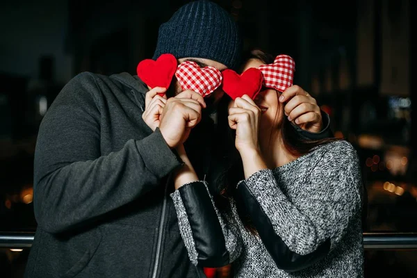 Feliz joven pareja cubriendo cada otros ojos con rojo almohada él —  Fotos de Stock