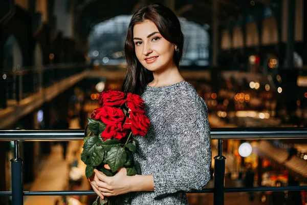 Jeune belle femme attrayante a obtenu un bouquet de roses rouges de — Photo