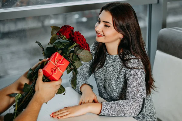 Романтическое свидание, привлекательная женщина получила розы и подарок от своего мальчика — стоковое фото