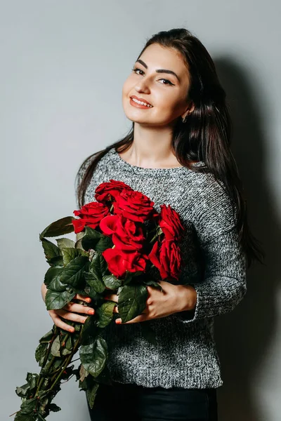 Jeune belle femme séduisante tenant bouquet de roses rouges. G — Photo
