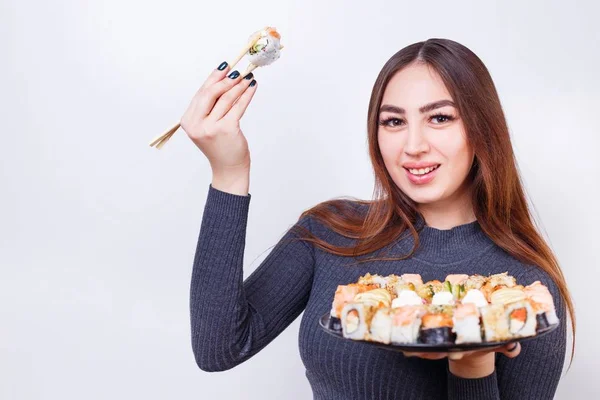 Retrato de jovem mulher atraente com conjunto de rolos de sushi, estúdio — Fotografia de Stock