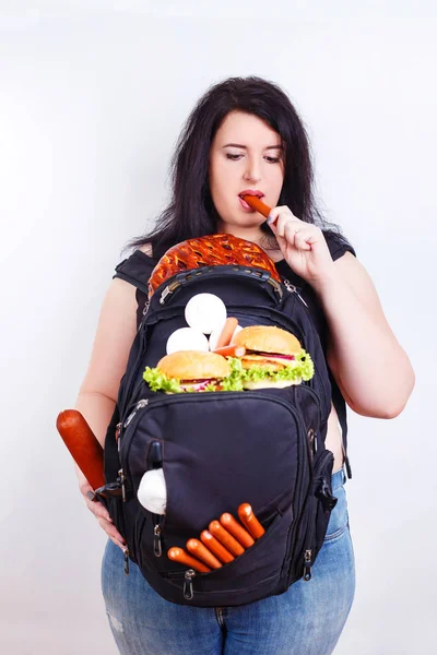 Mujer joven gorda obesa con una gran mochila llena de comida chatarra en —  Fotos de Stock