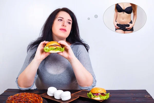 Mujer obesa con sobrepeso comiendo hamburguesa y soñando con ajuste y —  Fotos de Stock