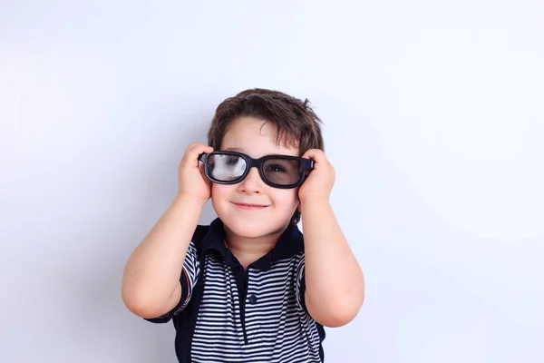 Felice ragazzo sorridente guardando attraverso gli occhiali da sole, riprese in studio su wh — Foto Stock