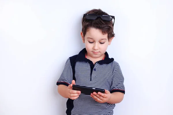 Söt pojke med smartphone. Barn surfa internet eller titta på vid — Stockfoto