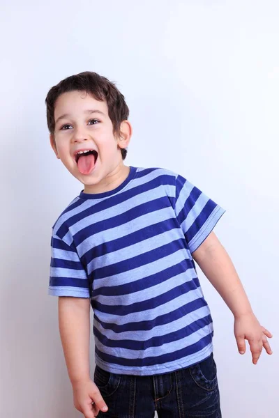 Zlobivý chlapec zobrazující jazyk, zblízka studio pro natáčení na Svatodušní — Stock fotografie