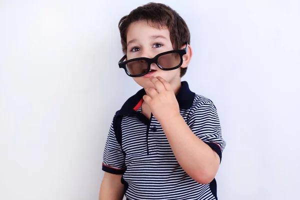 Rolig bild på söta lilla pojke att sätta på solglasögon, studio sho — Stockfoto