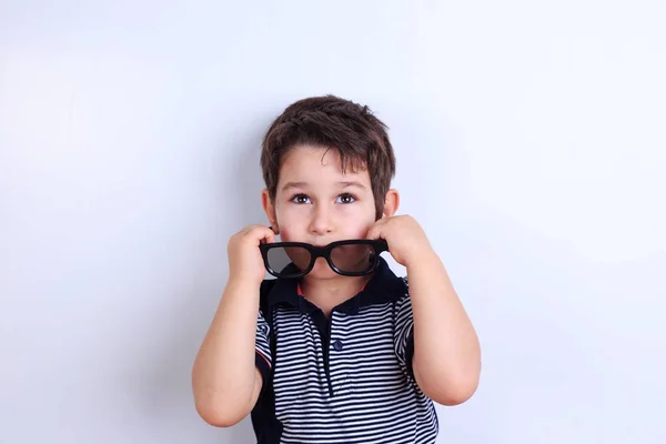 Lovely little boy putting off sunglasses, studio shoot on white. — Stock Photo, Image