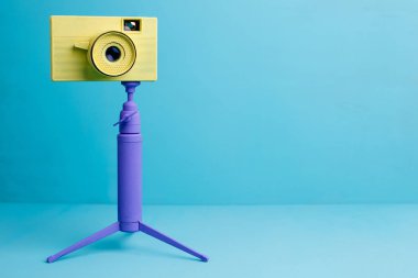 Parlak retro vintage fotoğraf makinesi tripod üzerinde mavi arka plan, kopya s