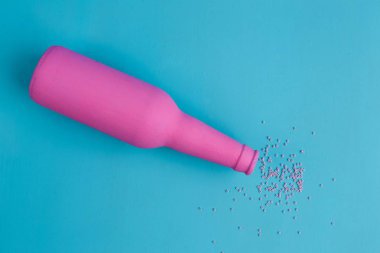 Pembe şişe ve mavi zemin üzerine serpilir boncuk, düz yatıyordu. Al