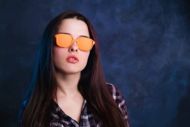 Turuncu retro güneş gözlüklü genç çekici kadın. Moda ve b