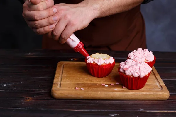 Chef confeiteiro decorar um cupcake com creme usando pastelaria b — Fotografia de Stock