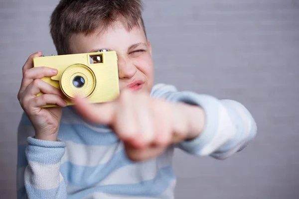 Boy taking a picture with vintage camera pointing on you. Photog — Stock Photo, Image