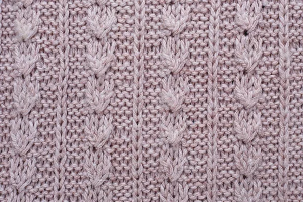 Knitted texture of beige woolen fabric with pattern. Copyspace,