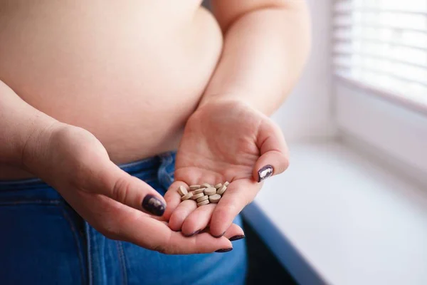 Donna in sovrappeso che prende pillole dimagranti. Modo malsano per essere magro — Foto Stock