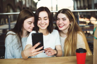 Üç genç kadın iyi eğlenceler ve selfie birlikte almak