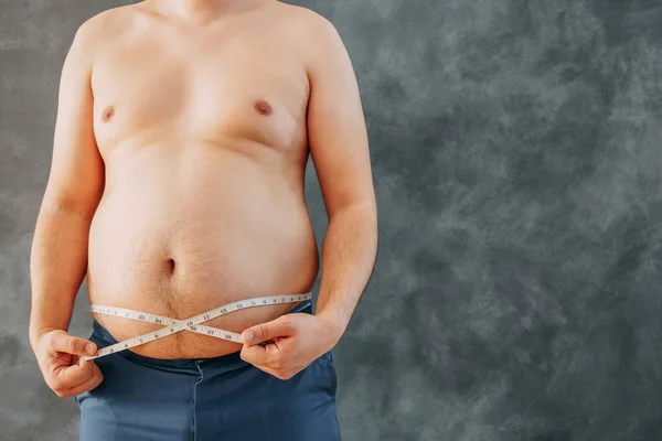 Hombre gordo con sobrepeso con cinta métrica en la cintura, copia de spac —  Fotos de Stock