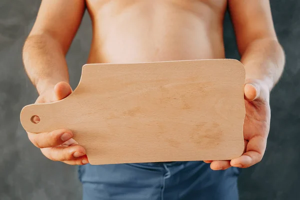 Hombre con sobrepeso sosteniendo la tabla de cortar vacía en las manos. Copiar espacio —  Fotos de Stock