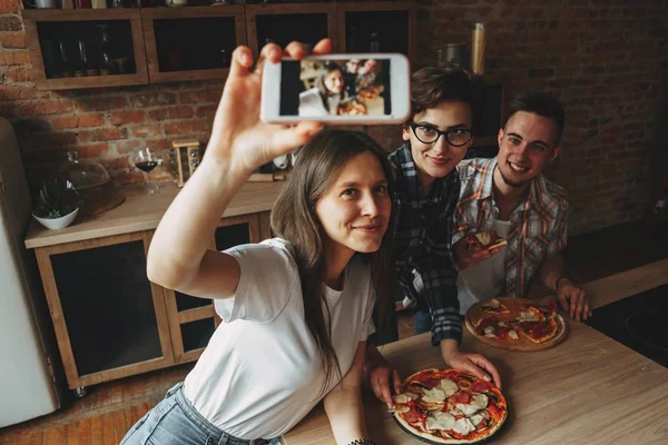Festa de pizza em casa. Amigos se divertir e comer pizza em casa cozinha — Fotografia de Stock